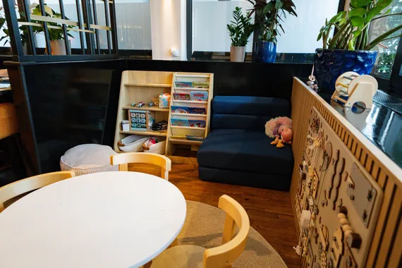 Kinderecke mit Spielwand, Bücherregal und Kindertisch im Restaurant AURO Langen