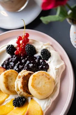 Frühstücksteller mit Quarkküchlein, Joghurt und frischen Beeren im Restaurant AURO Langen