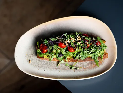 Belegtes Brot mit Rucola, Kirschtomaten und Kernen – Frühstück im Restaurant AURO Langen