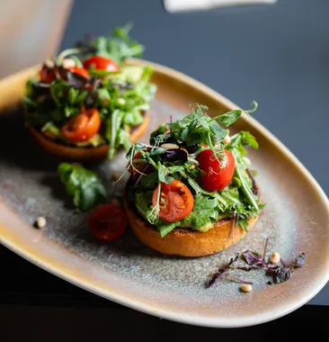 Zwei Bruschetta mit Avocado, Kirschtomaten und frischen Kräutern im Restaurant AURO Langen