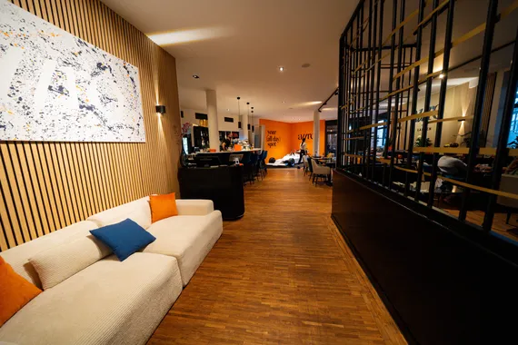 Lounge-Bereich mit gemütlichem Sofa und Kunstwerk an der Wand im Restaurant AURO Langen